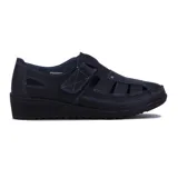 Zapato guillermina negro de cuero sintético, con punta cerrada, aberturas laterales, ajuste con velcro y suela de goma con plataforma baja.