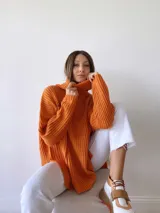 Zapatillas deportivas blancas con detalles en cuero color salmón y suela gruesa con detalles en naranja.