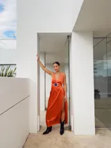 Vestido largo de satén color naranja, con escote en V, tajo lateral y cinturón con hebilla de alpaca y piedra ágata.