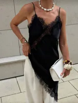 Vestido negro de satén con encaje en escote y ruedo, de corte asimétrico y breteles finos.