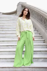 Pantalón fucsia de tiro alto, corte palazzo y aberturas laterales en el ruedo.
