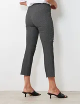 Pantalón negro con estampado geométrico blanco, de corte flare y pretina ancha elastizada.