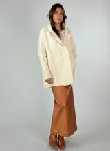 Saco tejido color crudo, con cuello solapa, mangas largas con puños acanalados y bolsillos delanteros de parche.