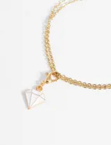 Dije en forma de diamante con gancho, de aleación de metales en color dorado.