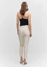 Pantalón skinny de corte crop, con dos bolsillos traseros, cierre oculto y tiro alto, confeccionado en mezcla de algodón.