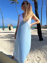 Vestido largo de lino sin mangas y con escote en V. Presenta un diseño bicolor con la parte superior en color blanco y el resto de la prenda en color celeste.
