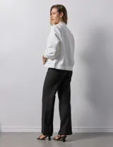 Campera bomber blanca con cuello a la base, abertura central con botones, bolsillos delanteros, ruedo y puños elastizados.