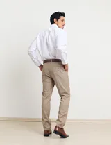 Traje de vestir color tostado, compuesto por saco con solapa de muesca, cierre de dos botones, bolsillos con solapa y pantalón de corte recto.