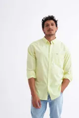 Camisa de manga larga en color amarillo, confeccionada en 100% algodón, con bolsillo en el pecho y botones personalizados.