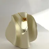 Collar plateado con dije en forma de rosa.