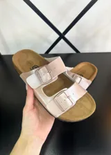 Sandalias de dedo color rosa con hebillas plateadas y plantilla de corcho.