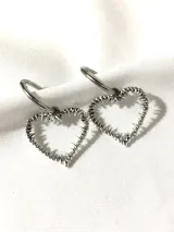 Par de aros plateados con forma de corazón con púas y cierre tipo argolla.