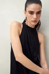 Vestido corto negro con cuello halter y corte recto.