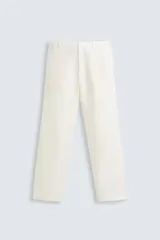 Pantalón de lino color blanco, de corte regular fit. Presenta cintura elástica, bolsillos frontales y traseros de plastrón, con cierre frontal de cremallera y botón.