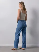 Pantalón jean de tiro alto, corte wide leg, color celeste, con bolsillos frontales y cordón ajustable en la cintura.