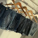 Short de jean elastizado con tiro alto, color negro gastado y flecos de strass.