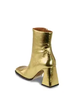 Botas de cuero dorado con tacón cuadrado y diseño de caña alta.