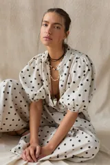 Camisa de lino color crudo con lunares negros, cuello mao, mangas abullonadas y cierre frontal con botones.