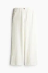 Pantalón de lino color blanco, de corte ancho y tiro alto, con bolsillos laterales y cierre frontal con botón.