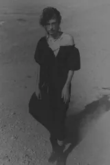 Vestido largo negro con escote cuadrado, cordón ajustable con borlas de cadena, mangas cortas abullonadas con forro y ribete elástico oculto, y costura fruncida bajo la cadera.