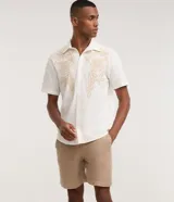 Bermuda de hombre color blanco crudo, confeccionada en algodón texturizado. Presenta un corte comfort, cintura elástica con lazo ajustable y bolsillos laterales.