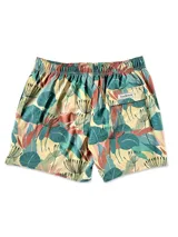 Short de baño blanco con estampado de hojas de palmera en tonos verde, rojo y amarillo.