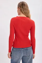 Polera roja de punto de rib con cuello alto y mangas largas.