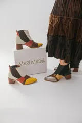 Botinetas de cuero con diseño patchwork en negro, dorado, plateado y marrón. Tienen elásticos laterales, taco cuadrado de madera y puntera fina.