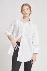 Camisa blanca de corte holgado con detalles de encaje en el frente y en las mangas.