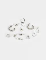 Set de aros dorados con diferentes diseños: aros tipo argolla, aros con forma de corazón, aros con perlas, aros con strass y aros tipo botón.