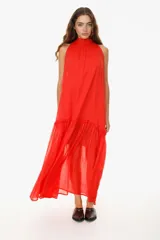 Vestido largo blanco de algodón con cuello halter y falda escalonada con volados.