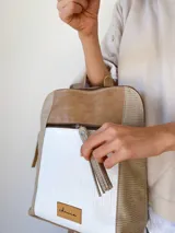 Mochila beige con detalles en blanco y marrón.