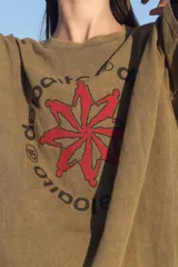 Remera verde militar de corte amplio con estampa en el frente con texto en español y siluetas rojas.