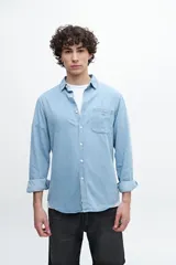 Camisa de denim de manga larga, confeccionada en 100% algodón, con bolsillo en el pecho y botones personalizados.