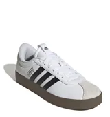 Championes Adidas VL Court 3.0, color blanco con detalles en negro y suela marrón. Inspirados en el skate, con exterior de cuero y gamuza, las tres tiras clásicas de Adidas en los laterales y suela vulcanizada.