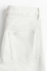 Jean de cinco bolsillos color blanco, de corte ajustado con tiro alto y piernas tobilleras.