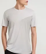 Remera deportiva gris de poliéster con cuello redondo y mangas cortas. Presenta un diseño degradado en el frente y protección UV.