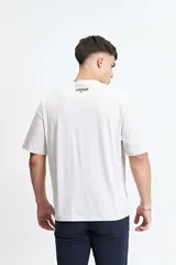 Remera de manga corta color crudo, de corte holgado y hombros caídos.