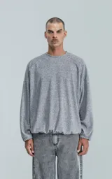 Sweater gris de corte holgado, cuello redondo y puños ajustados.
