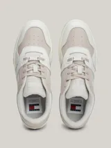 Zapatillas urbanas Tommy Jeans de corte bajo, con exterior de piel en tonos blanco, gris y beige. Presentan suela gruesa de goma, cordones y logo de la marca en el lateral y el talón.