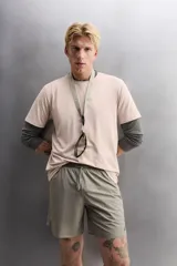 Shorts de entrenamiento color verde oliva, confeccionado en tejido técnico ligero y elástico con perforaciones. Tiene forro interior, cintura elástica ajustable con cordón, bolsillos laterales, bolsillo trasero con cierre de cremallera, bajo con aberturas laterales y logo estampado en la pierna.