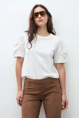 Remera blanca de cuello redondo con mangas cortas abullonadas de diseño voluminoso.