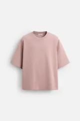 Camiseta rosa de corte recto, cuello redondo y manga corta. Estampado con efecto grabado combinado a tono en la espalda.