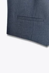 Chaleco negro con escote en pico, sin mangas y cierre frontal con botones.