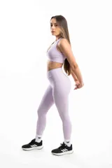 Conjunto deportivo lila compuesto por un top deportivo con escote en V y calzas largas con bolsillos laterales.