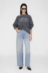 Buzo gris oscuro de corte amplio, con cuello redondo y terminaciones acanaladas. Estampa frontal con texto en color gris claro.