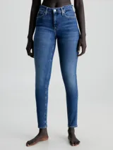Jeans de denim azul medio vintage, corte skinny, tiro medio, cinco bolsillos y cierre con cremallera.