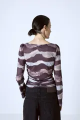 Top de tul con estampado abstracto en tonos marrones y grises, de mangas largas y cuello redondo.