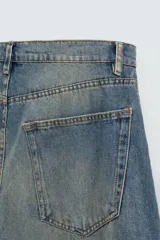 Pantalón de jean celeste con efecto lavado, corte amplio tipo balloon fit, tiro medio, cinco bolsillos y cierre frontal con cremallera y botón.