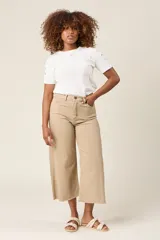 Pantalón jean corte culotte color beige, con tiro alto, bolsillos delanteros y traseros, y terminación desflecada.